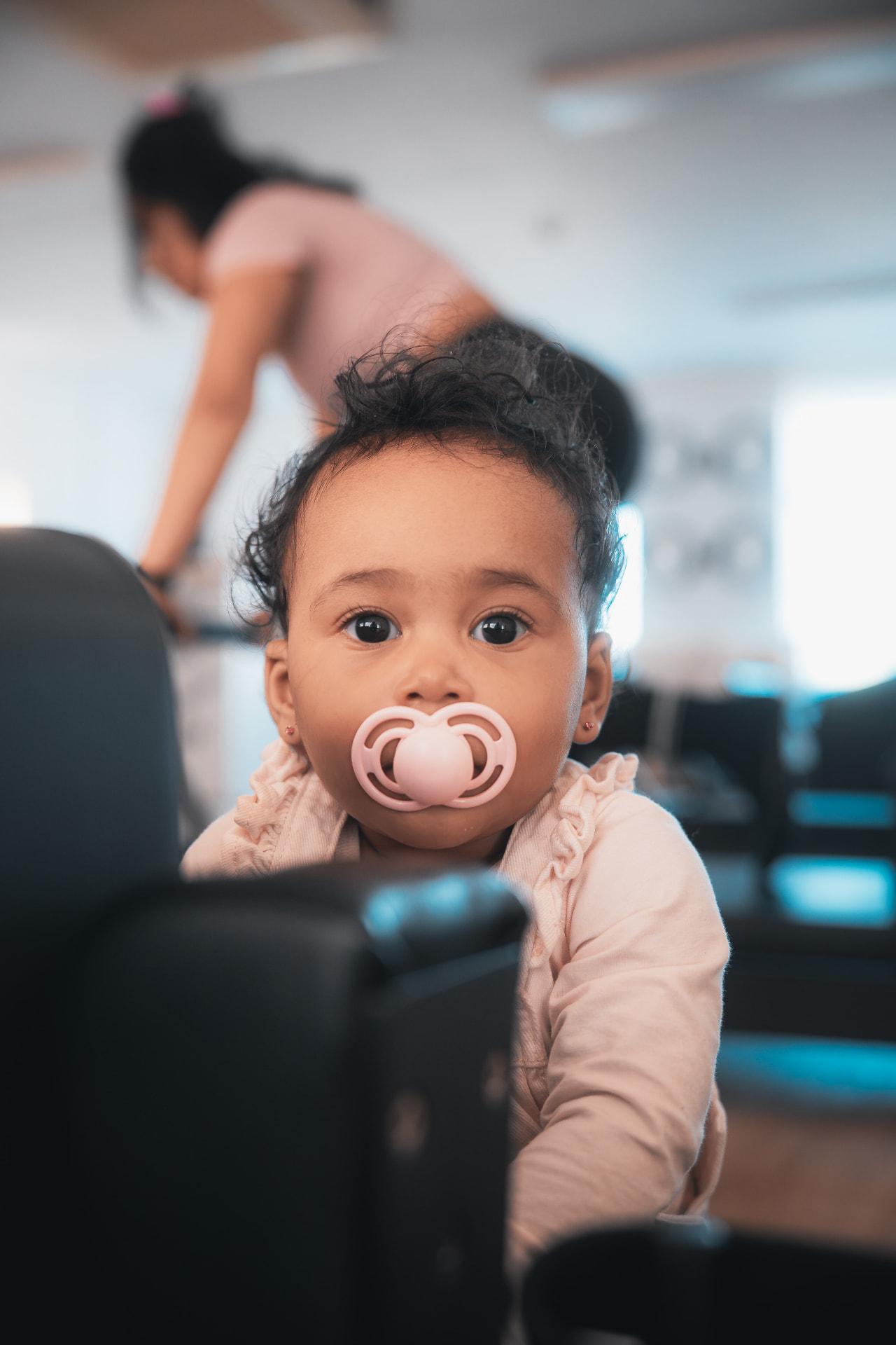 Baby watching their parent train in the Pilates studio