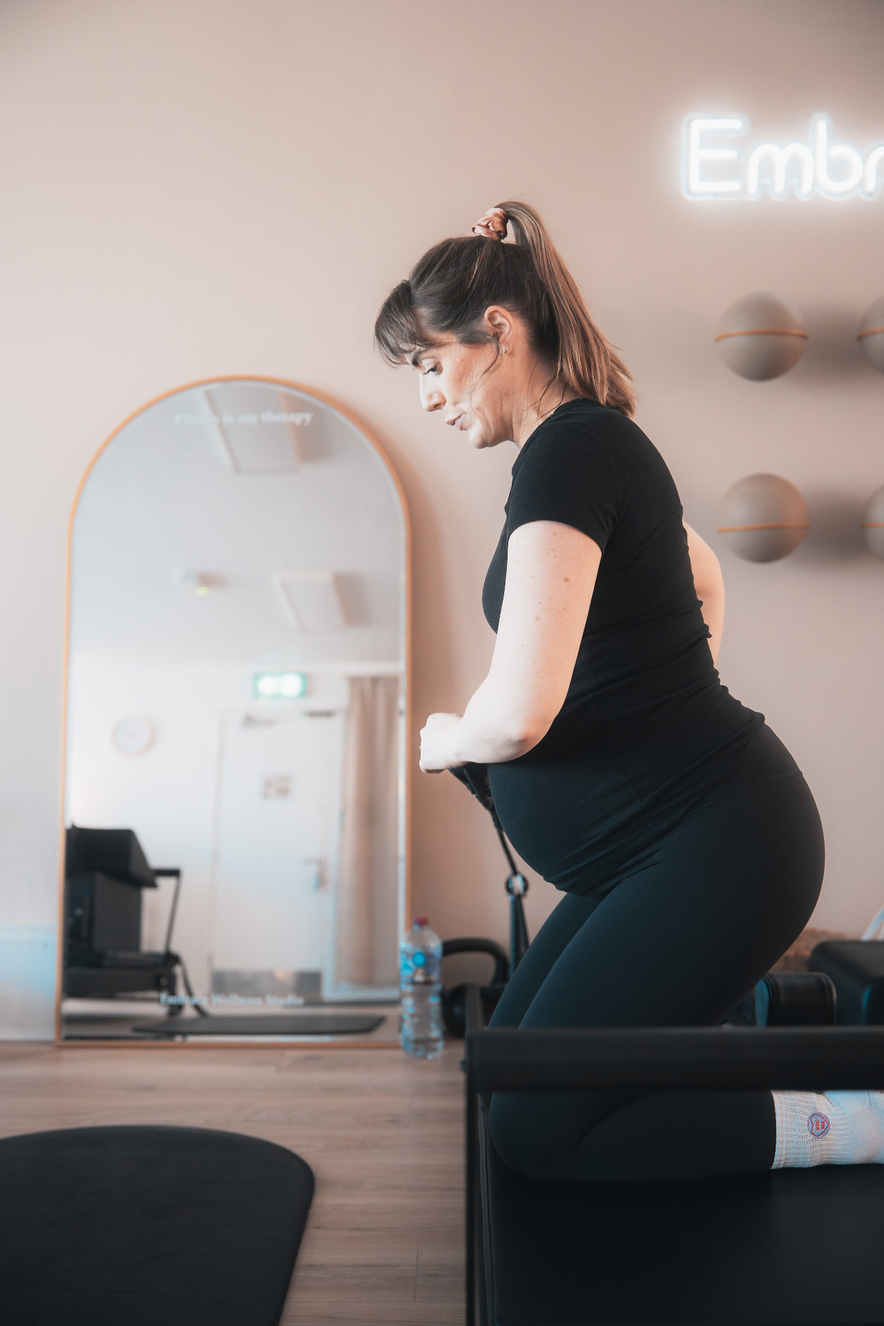 Pregnant client working through a standing exercise in the studio